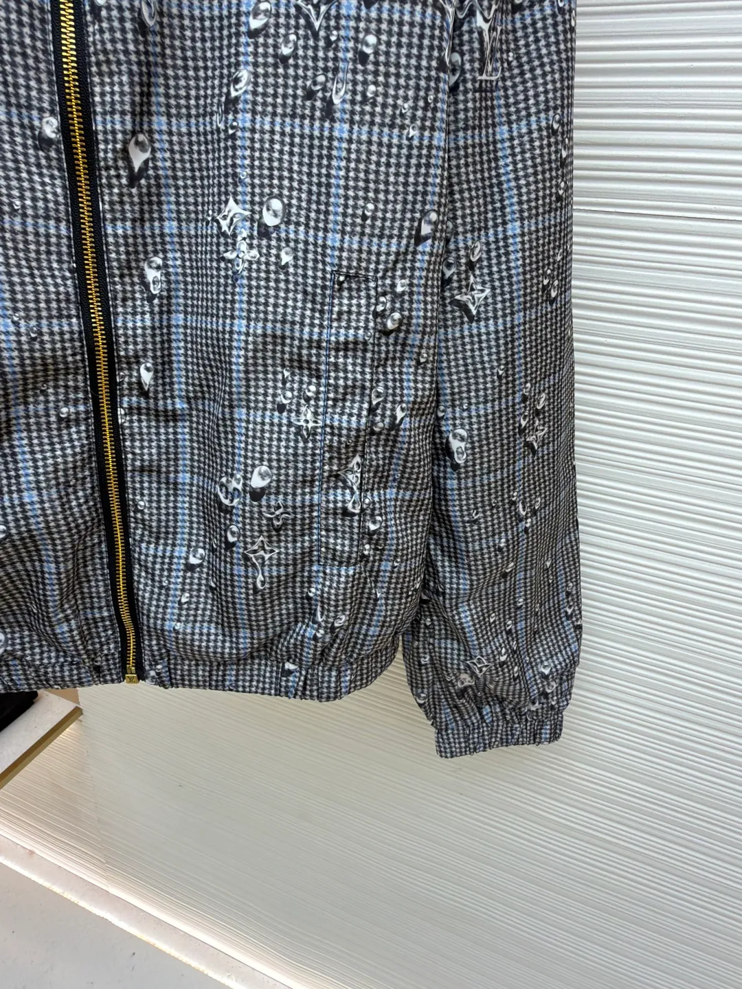 LOUIS VUITTON double-sided hooded raindrop printed windproof jacket ●Original version: 23999 purchase and development ●Item number: 1681911-B40 ●Fabric: nylon fabric ●Technology: printing production ●Color: gray ●Version: fitted version ●Weight: about 460 grams ●Size: S-M-L-XL ●Description: This lightweight double-sided windproof jacket presents two different styles: a vivid Monogram Waterdrop on one side The print consists of playful Monogram logos raining down on elegant Prince of Wales check. The other side is a timeless dark color, complemented by a subtle monogram jacquard in the same color. Easy to store, it's the perfect choice for a cozy weekend in the countryside or a rainy stroll in the city. Body: 100% polyester; Lining: 100% nylon; Other: 100% cotton, Drawstring hood Elasticized cuffs and hem Logo printed at outer side, jacquard logo pattern at inner side Zip at front Trim pockets. The overall wiring is straight and delicate, the fabric is comfortable and soft, and the color is consistent without color difference. It can be matched with the same style to create a fashionable look and control various occasions. Customized accessories, complete with three standards, same style for men and women!